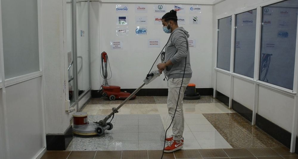 persona limpiando el suelo con una máquina
